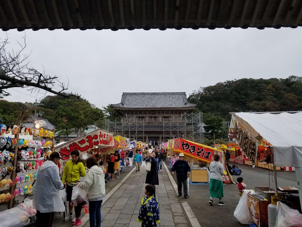 光明寺の十夜法要　本堂の方から山門を眺めた参道の様子　屋台や屋台で買い物をする人たち