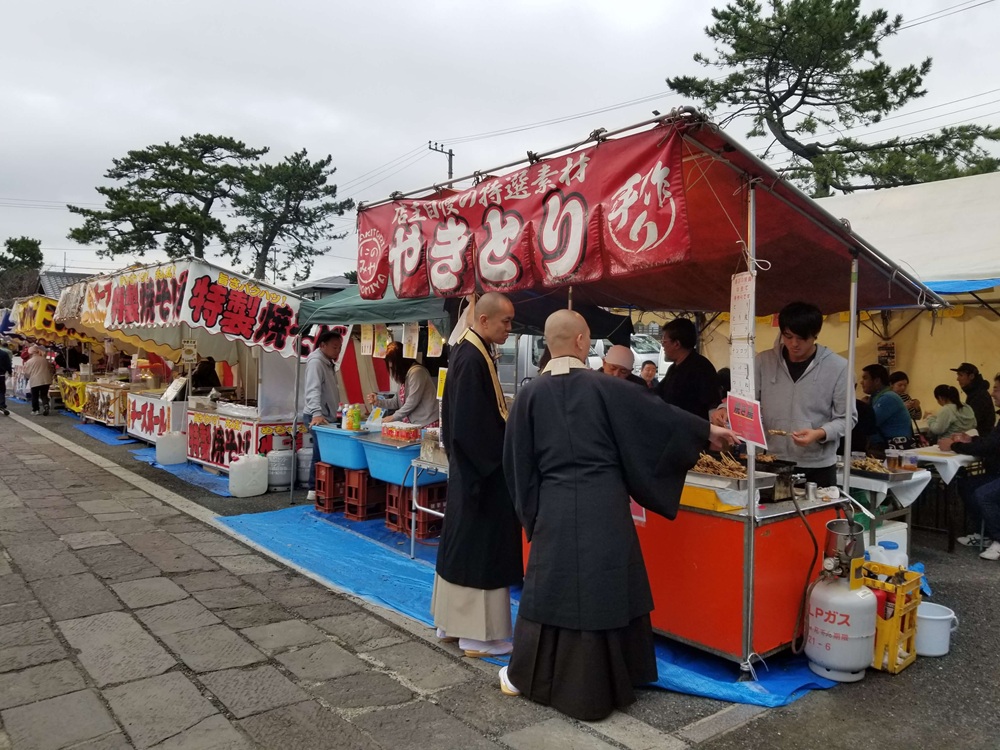 光明寺十夜法要　屋台での風景　僧侶が買い物をしています