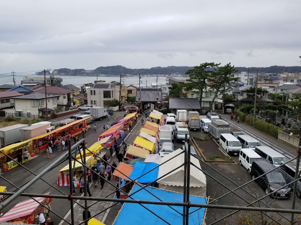 光明寺十夜法要　山門から見た海の景色と眼下にある屋台の様子