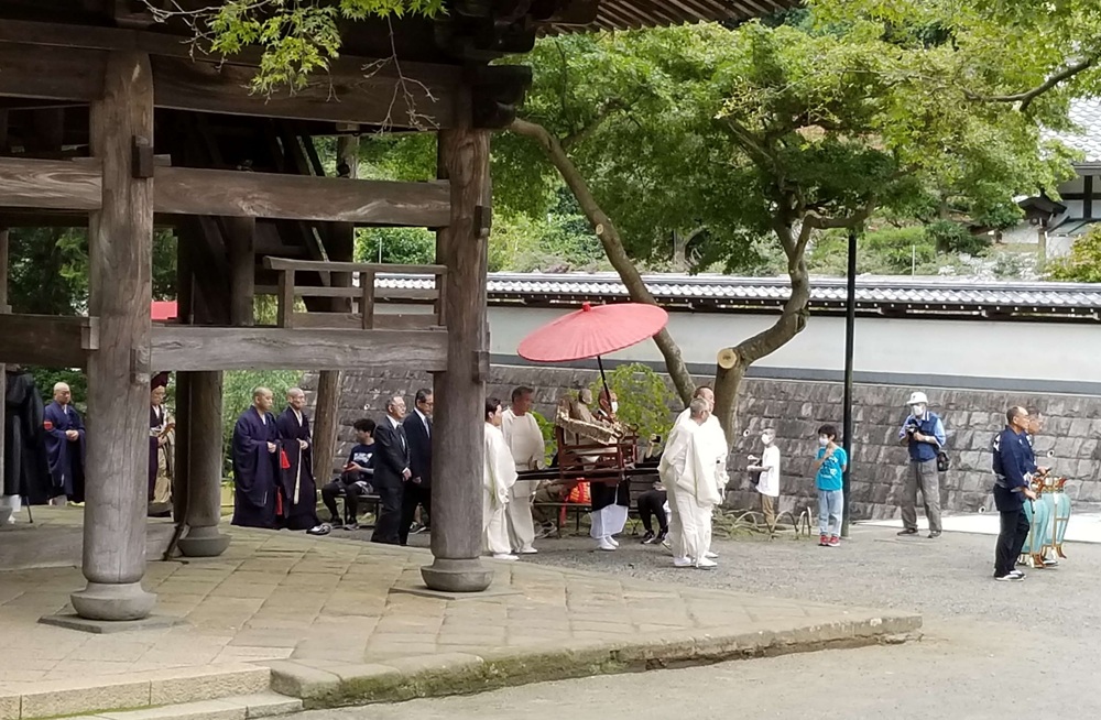 円覚寺の山門を歩く神輿に乗せた仏光国師像と僧侶たち
