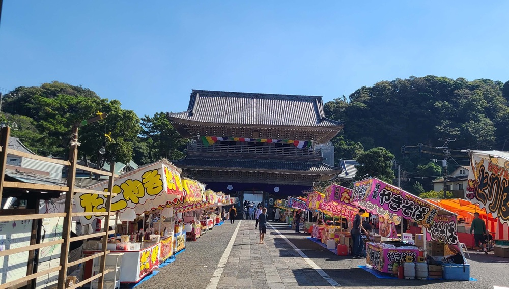 光明寺の十夜法要　本堂の方から山門を眺めた参道の様子　屋台や屋台で買い物をする人たち