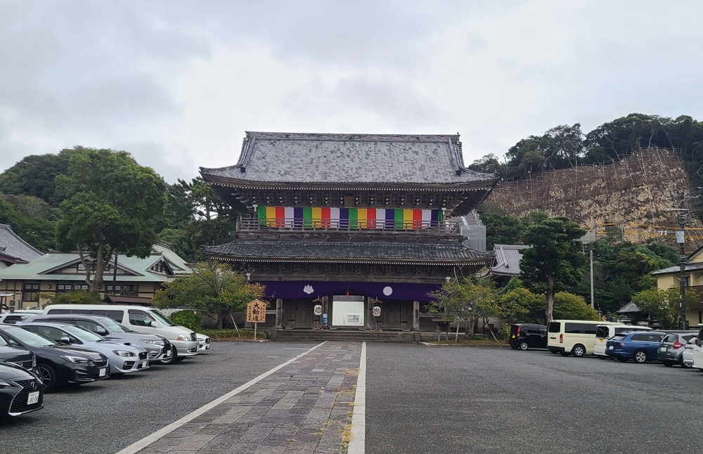 光明寺の山門を総門から見た　手前には数十大の車