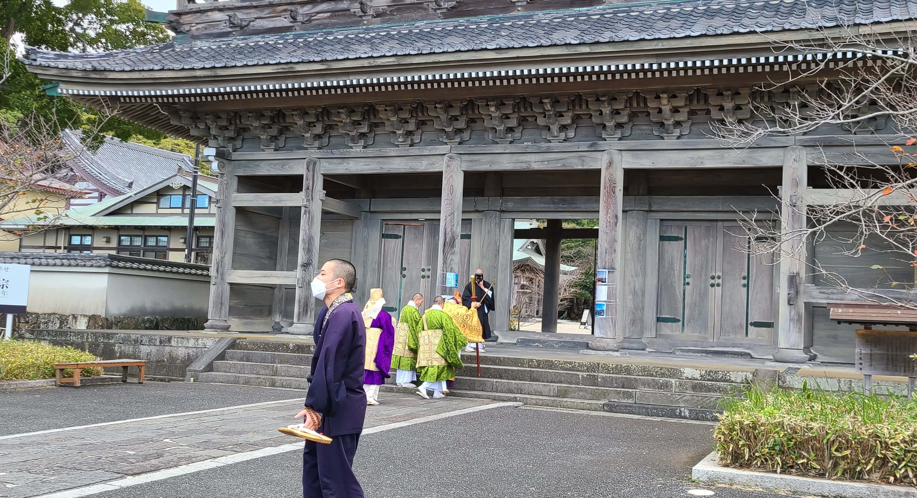 光明寺の山門を通る天狗と僧侶たち