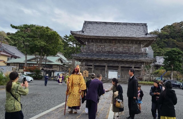 法要が終わり山門まで戻ってきた天狗と僧侶たちと写真を撮る人達