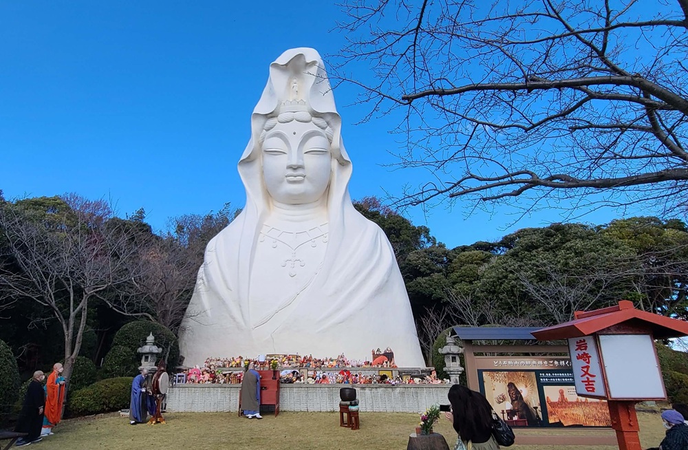 大船観音とその前に置かれた多数の人形やぬいぐるみ